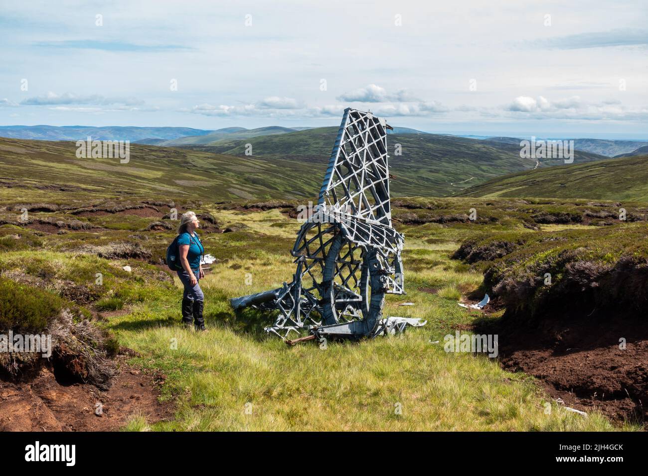 Walker looks at part of the tail of a Vickers Wellington bomber wreckage that crashed in 1942 on a hill near Ben Tirran in Glen Clova, Angus, Scotland Stock Photo