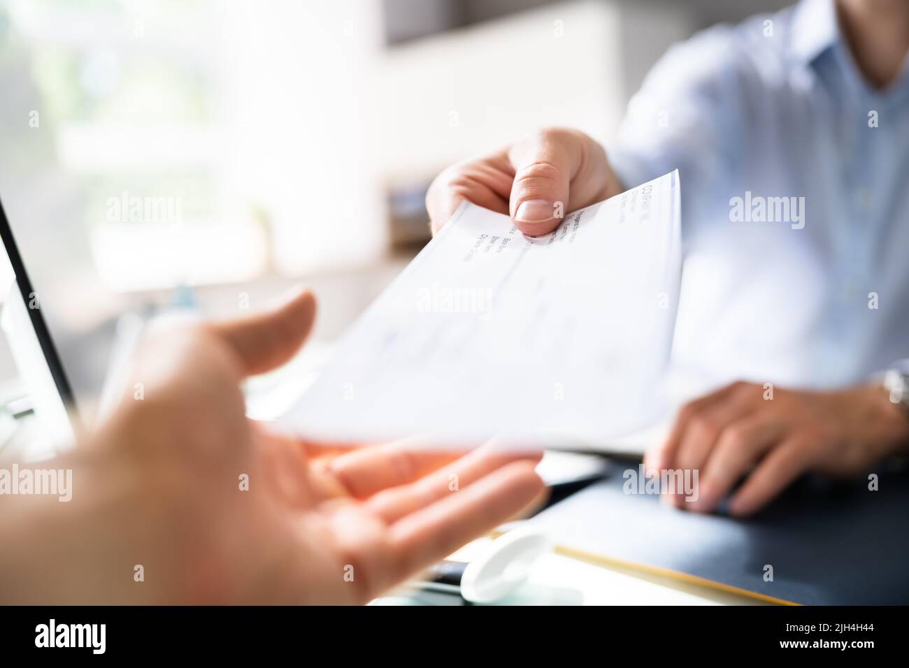 Businessperson Hands Giving Cheque To Other Person Stock Photo