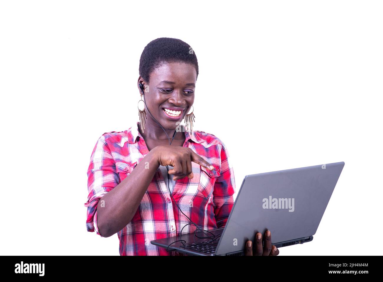 beautiful happy young woman, with earphones in her ear, pointing finger ...