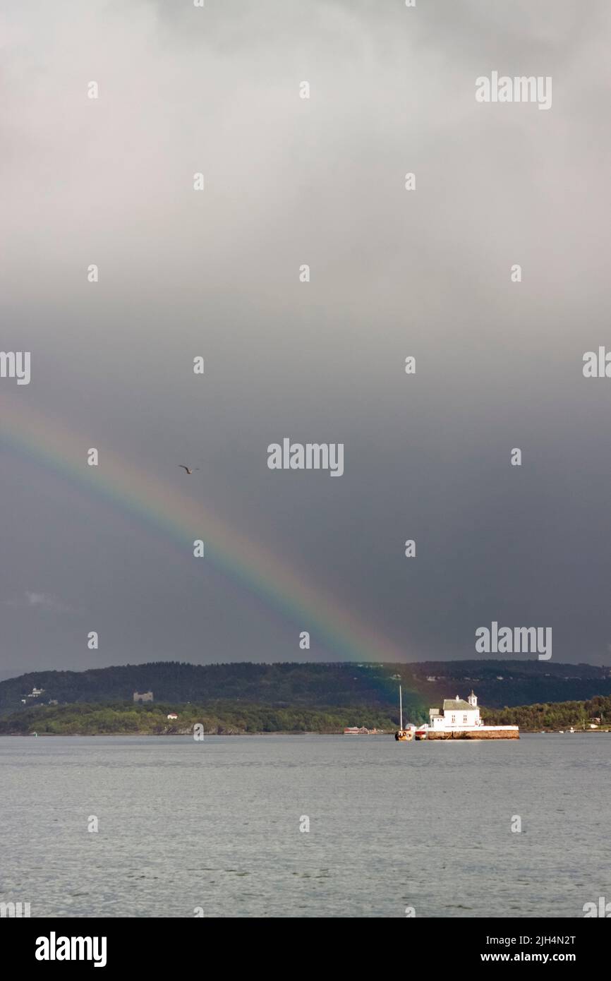 Little island in oslofjord after the storm remains the rainbow. Oslo, Ostlandet. Norway Stock Photo