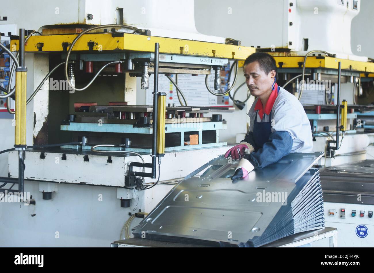 HANGZHOU, CHINA - JULY 15, 2022 - An employee shapes the metal shell of a new range hood at a workshop in Xiaoshan Economic Development Zone in Hangzh Stock Photo