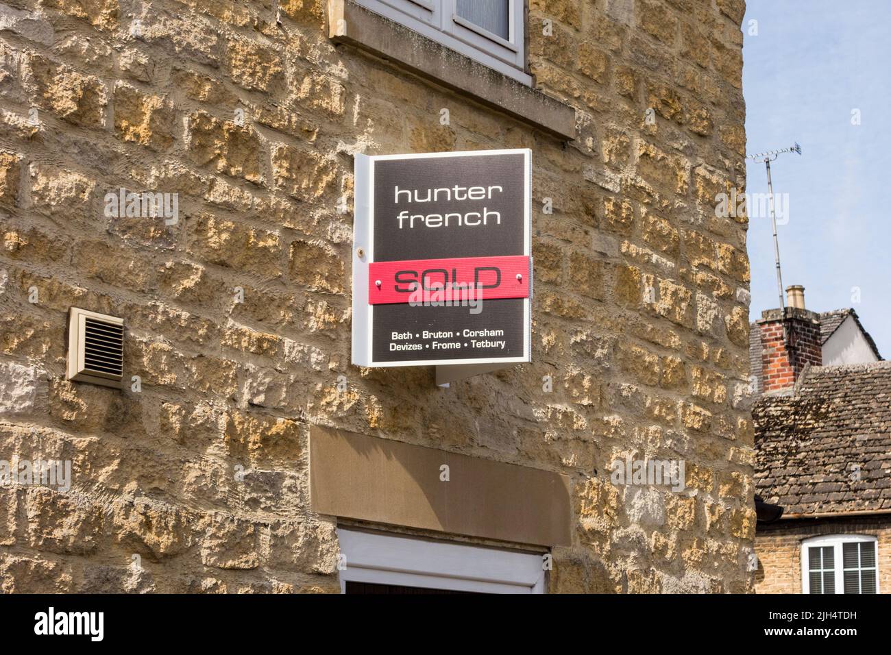 Sold sign by easte agent attatched to wall of house, Tetbury, Gloucestershire, UK Stock Photo