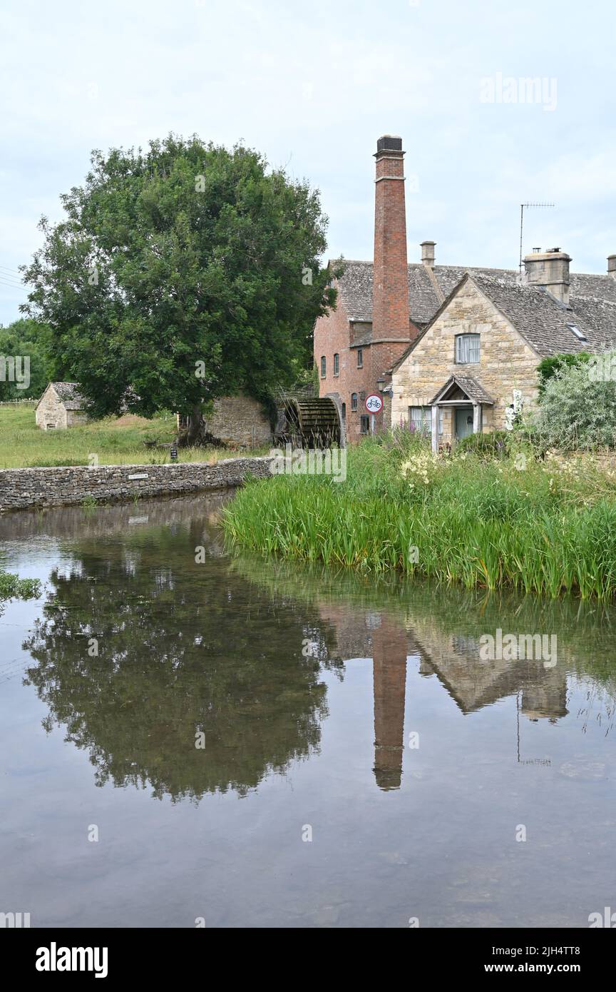 The Old Mill stands on the River Eye in the Gloucestershire village of Lower Slaughter. The mill's reflection can be seen in the water Stock Photo