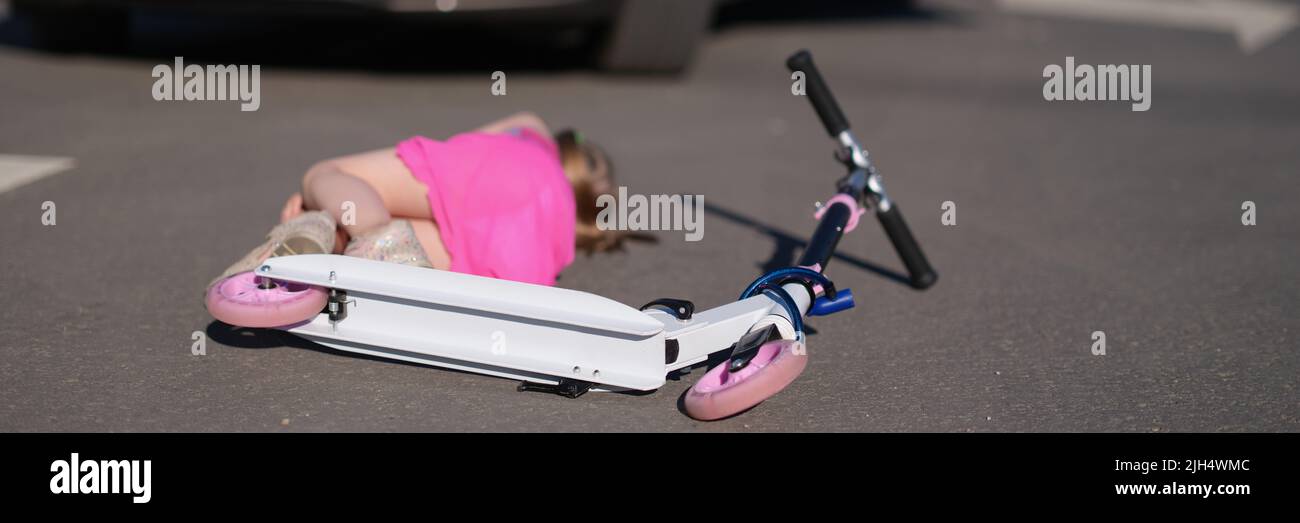 Little girl on scooter hit on road by automobile, road accident Stock