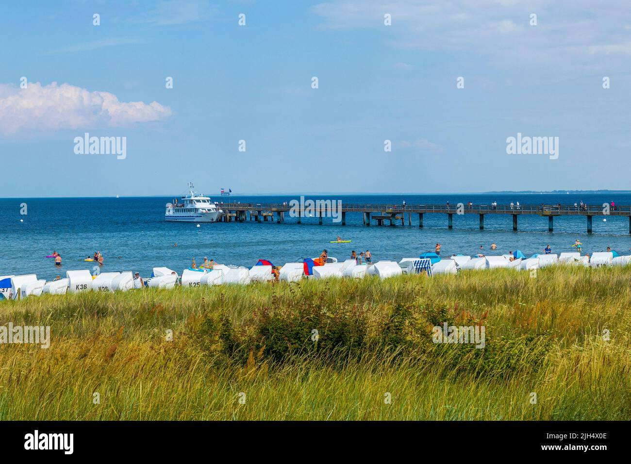 Boltenhagen, Mecklenburg-Western Pomerania, is a holiday destination with many possible leisure activities. Beach chair, sea bridge, white ship. Stock Photo