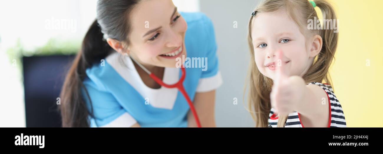 Girl being examined by pediatrician doctor, happy child show thumbs up gesture Stock Photo