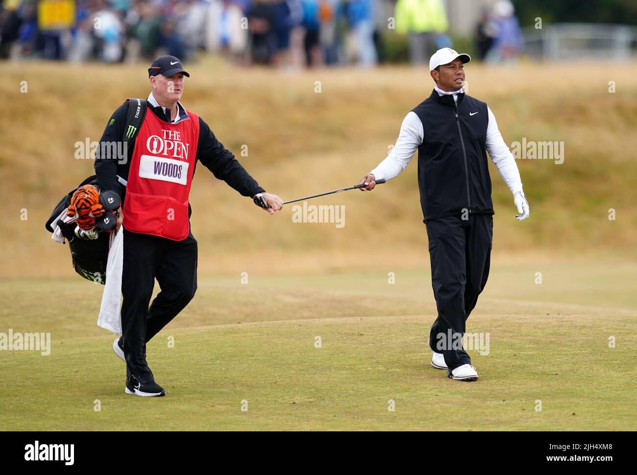 Tiger Woods and caddie Joe LaCava walk out of the pine straw on the front  nine in the fourth round of the Masters at Augusta National on April 14,  2013 in Augusta,