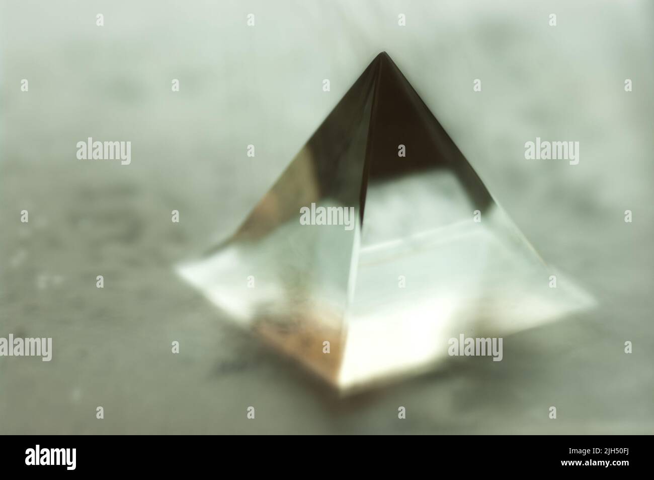 Blurry image of a glass pyramid. Abstract still life image of a geometric object. Stock Photo