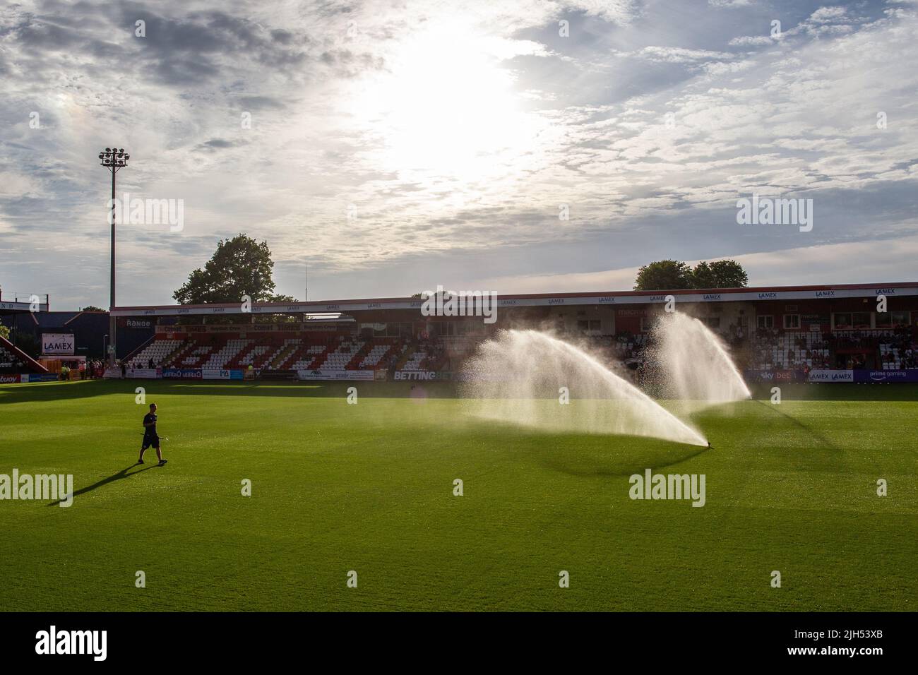 Water sprinkler system in operation at football stadium ahead of match. Stock Photo