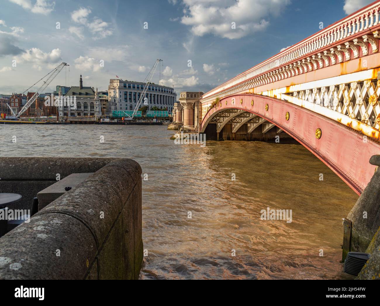 At the South Bank of the river Thames,on a hot, sunny early evening in mid summer,the historic bridge's beautiful pink facade and rustic architectural Stock Photo