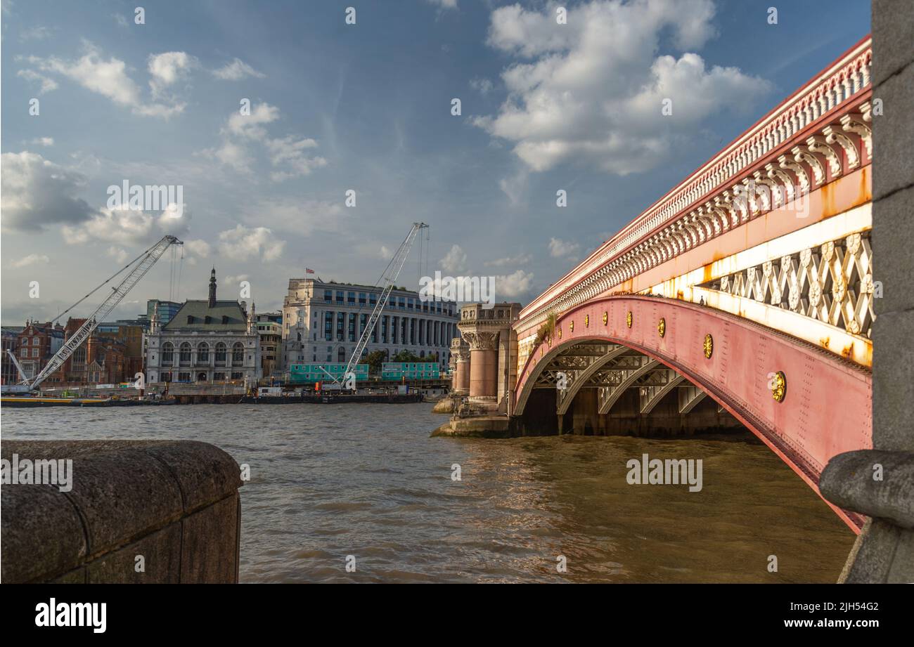 At the South Bank of the river Thames,on a hot, sunny early evening in mid summer,the historic bridge's beautiful pink facade and rustic architectural Stock Photo