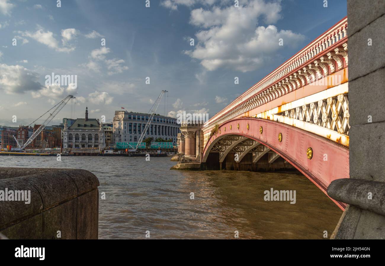 At the South Bank of the river Thames,on a hot, sunny early evening in mid summer,the historic bridge's beautiful pink facade and rustic architectural Stock Photo
