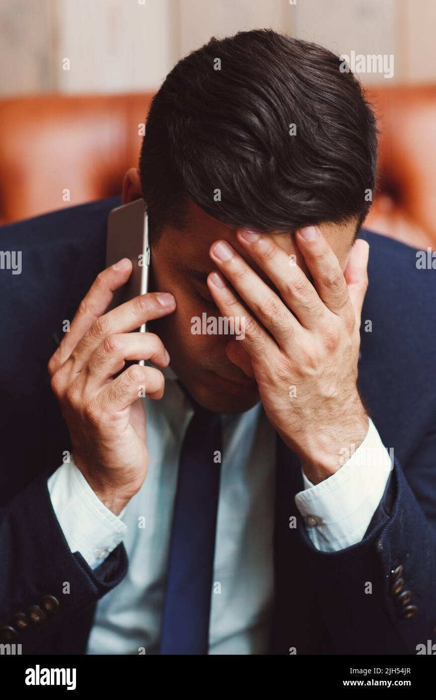 Depressed businessman talking on phone Stock Photo