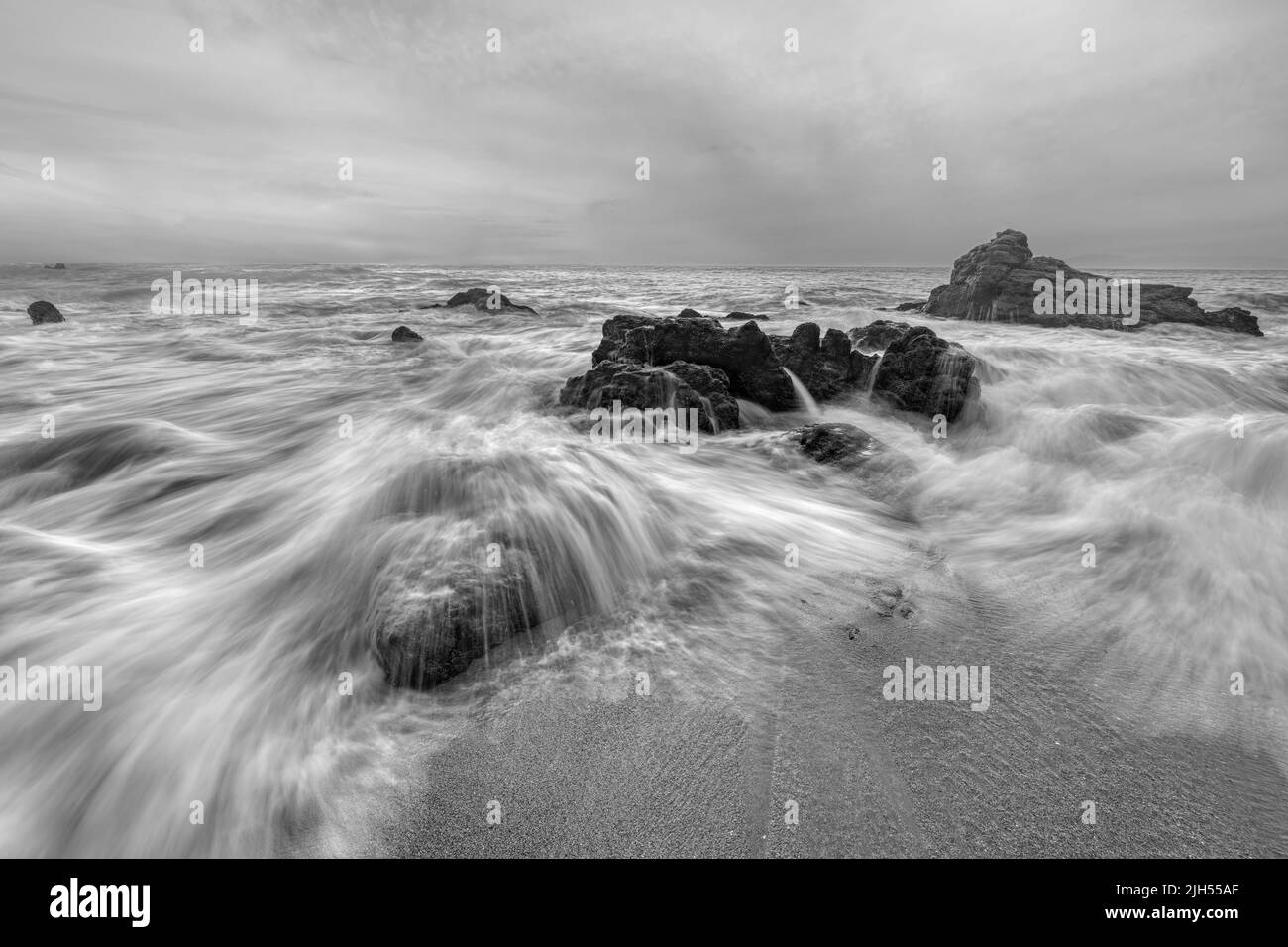 Water Is Flowing Through Ocean Rocks Black And White Stock Photo