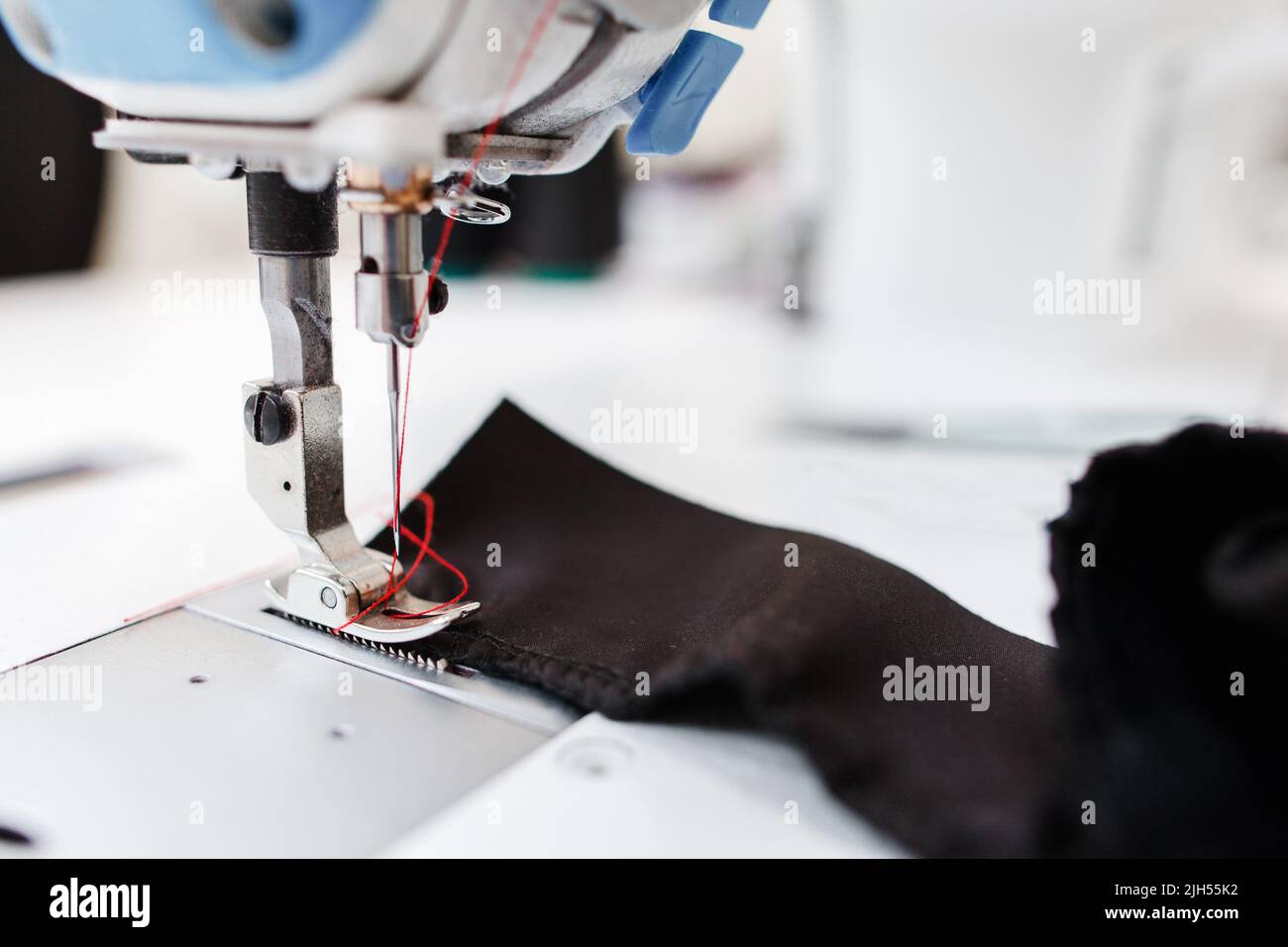 Sewing machine stitching dark fabric close-up Stock Photo