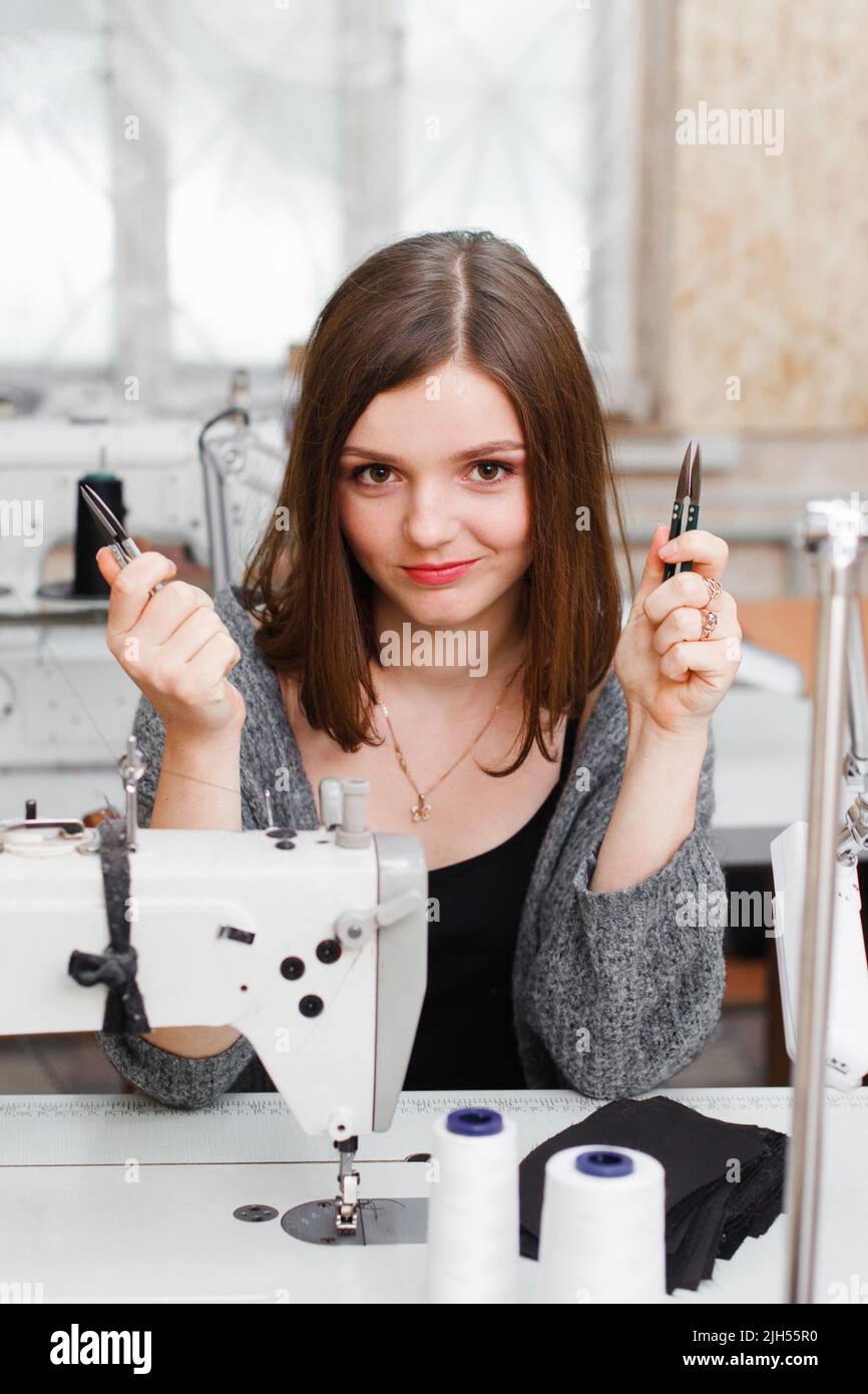 Young smiling seamstress posing with scissors Stock Photo Alamy