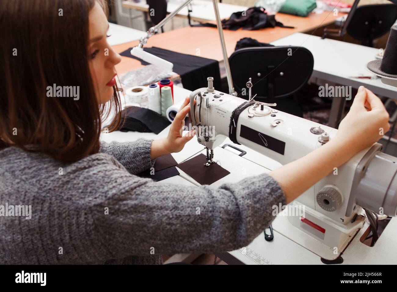 Seamstress tuning sewing machine for work Stock Photo Alamy