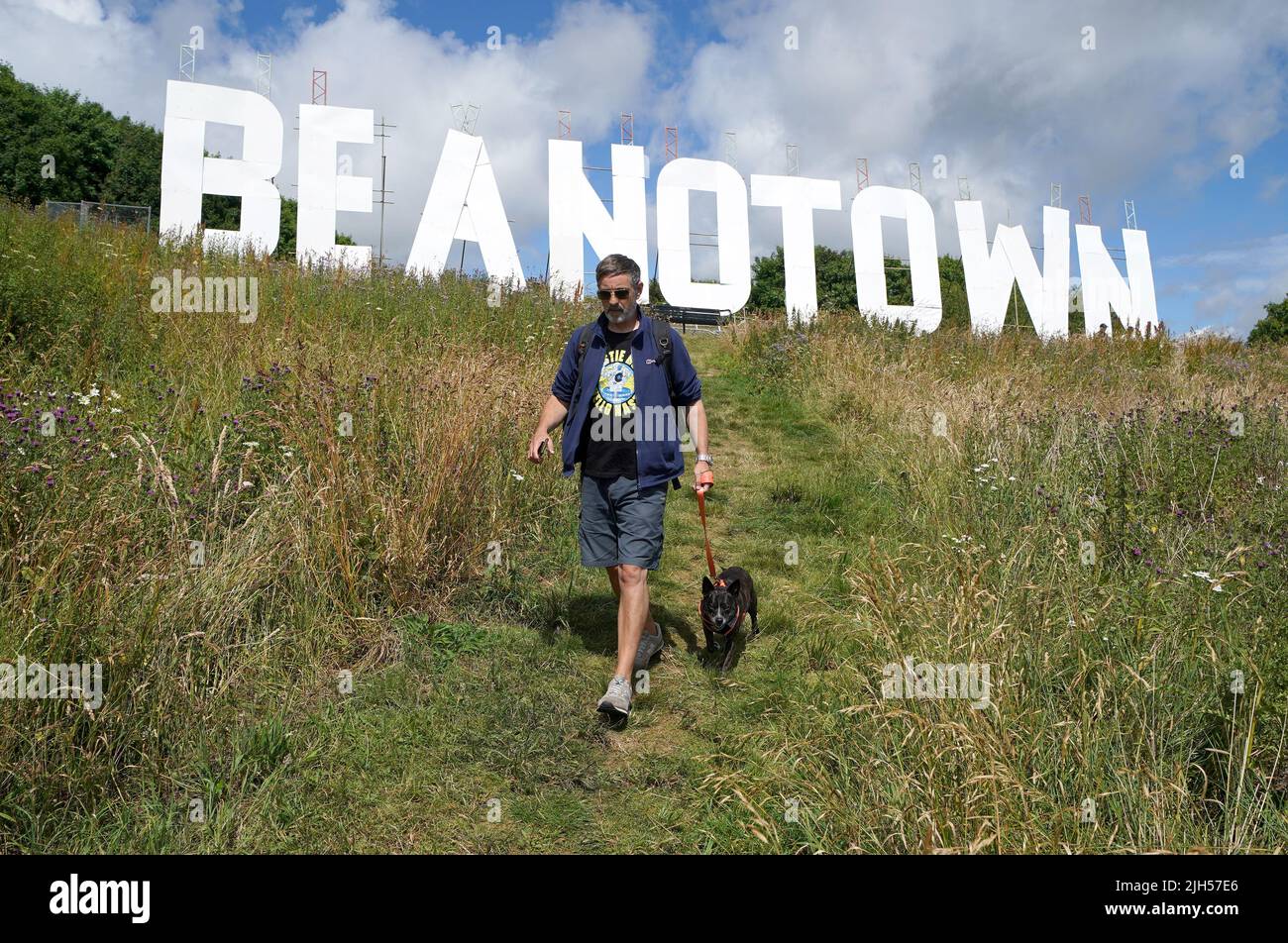A dog walker passes a giant sign erected at Dundee Law renaming the