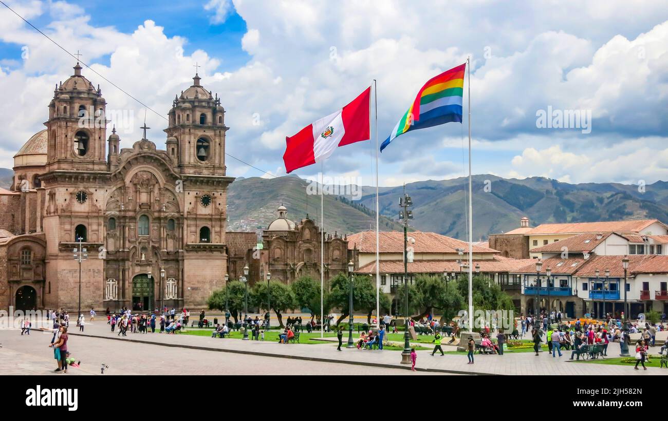 Cusco, Peru.Feb. 5, 2017: Peruvian and Tahuantinsuyo flag on the main square of Cusco, Peru with the church of the company of Jesus in background. Stock Photo