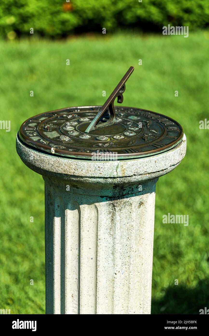 antique sundial on a pedestal in sunny day in garden, New Jersey Botanical Garden Stock Photo