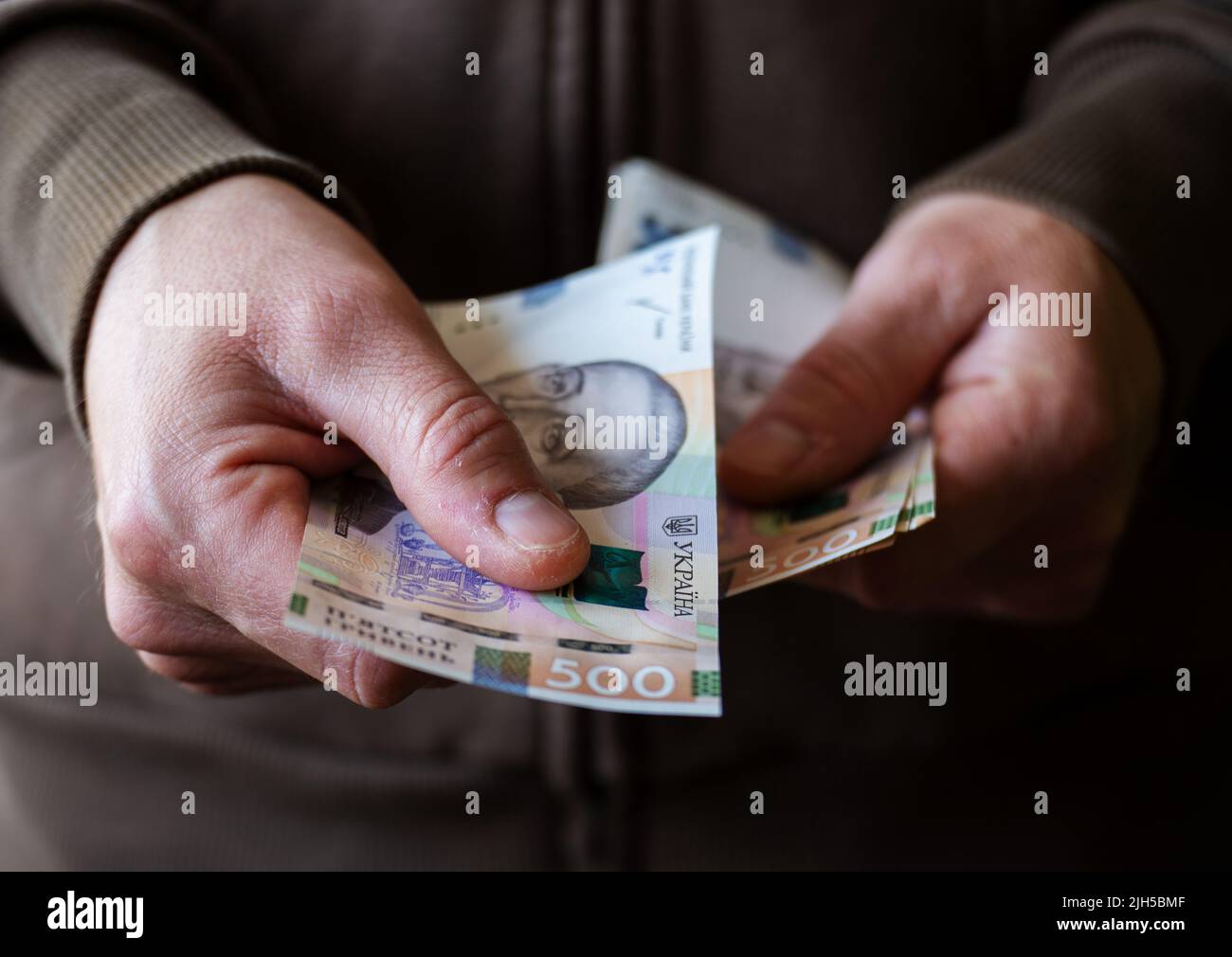 White man giving Ukrainian money bills closeup Stock Photo