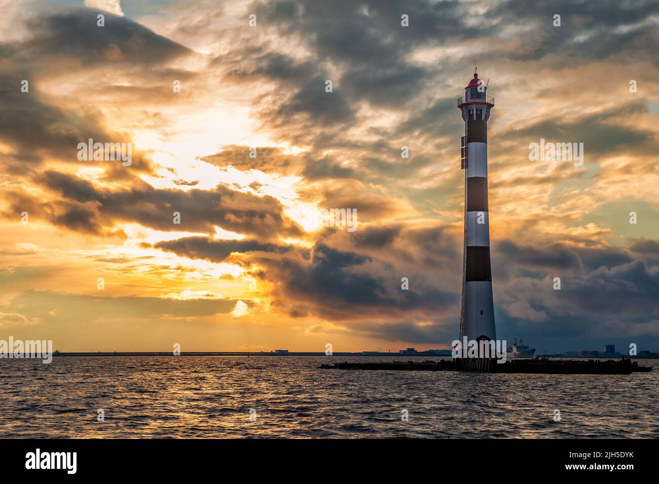 Lighthouse leading lights of the Sea Canal in the Gulf of Finland against the backdrop of a stormy sunset sky. Stock Photo