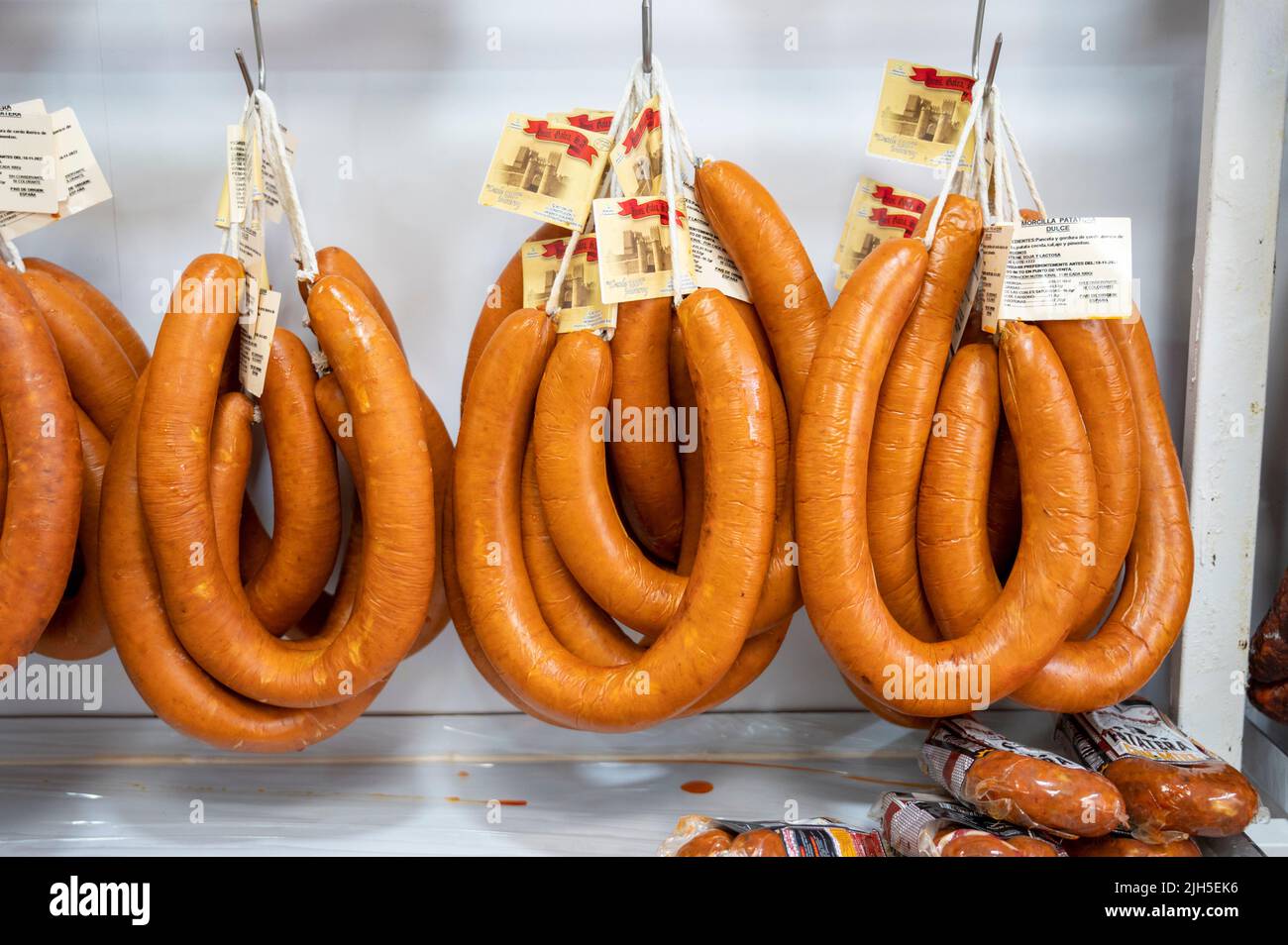 Sausages or charcuterie hanging up for sale in a shop in Spain Stock Photo