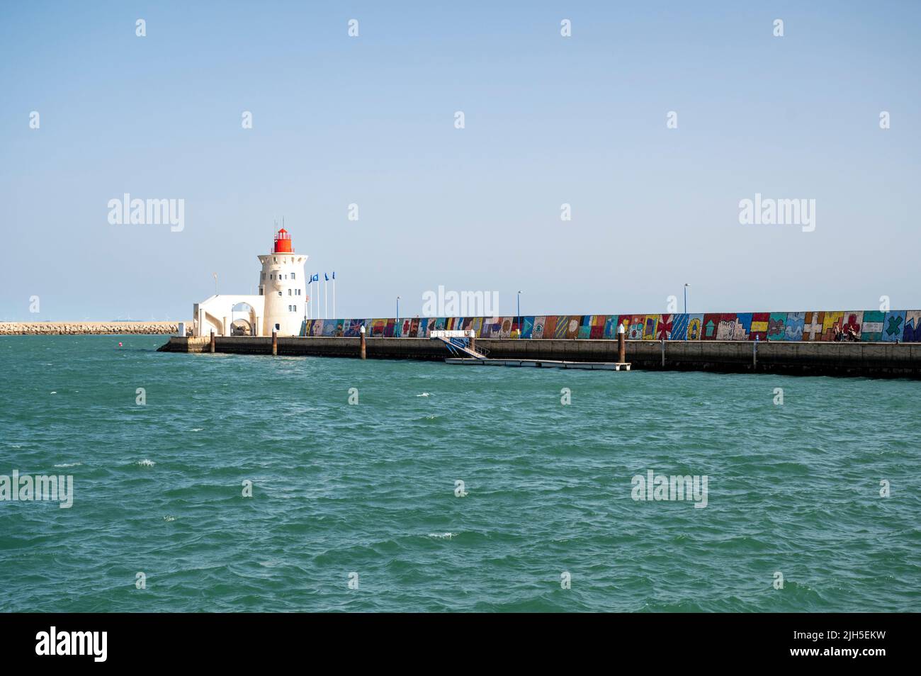 The sea wall and lighthouse at Rota marina Spain Stock Photo