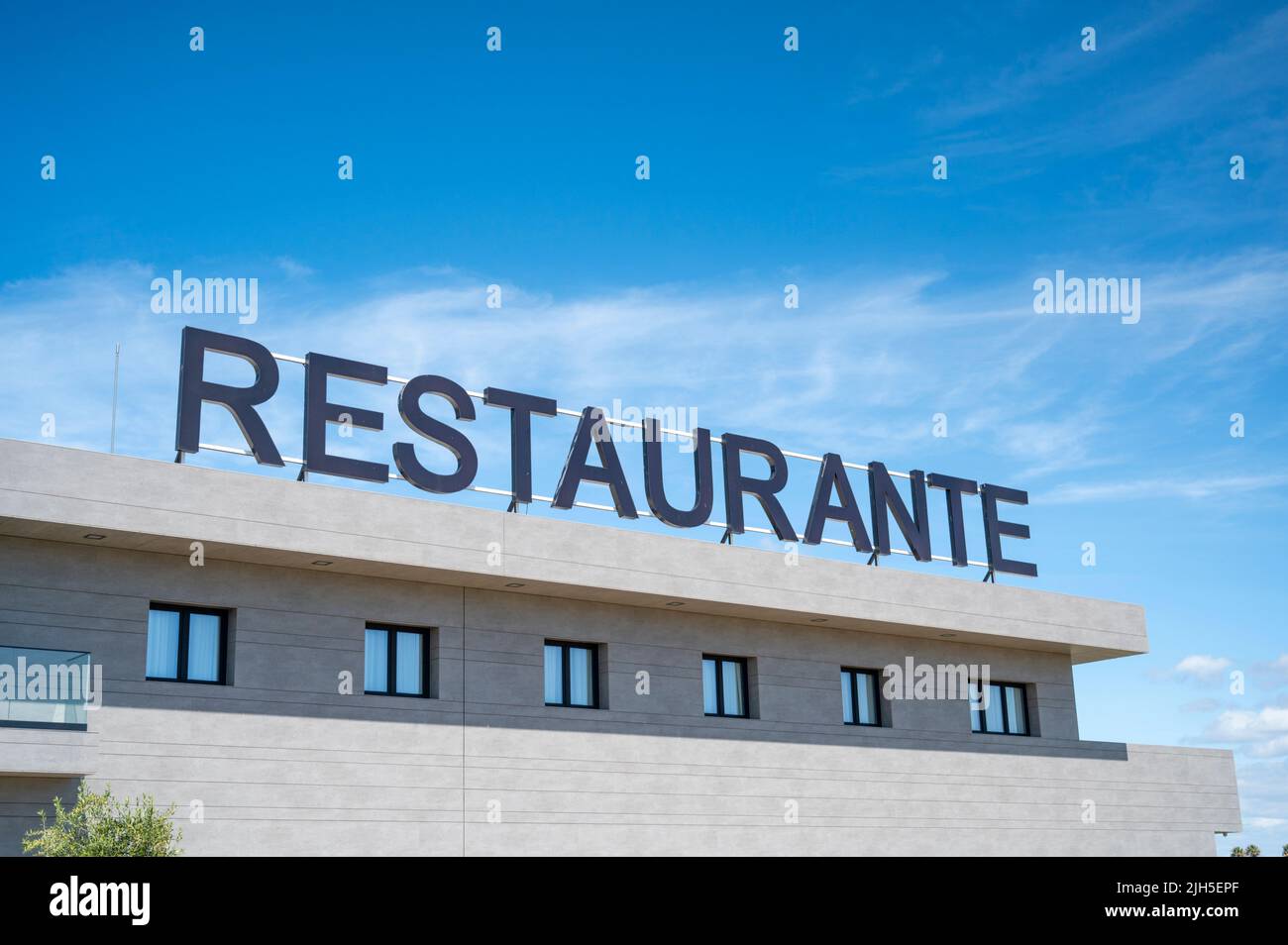 A Repsol restaurant and hotel advertising sign at a service area in Spain against a colourful blue sky Stock Photo