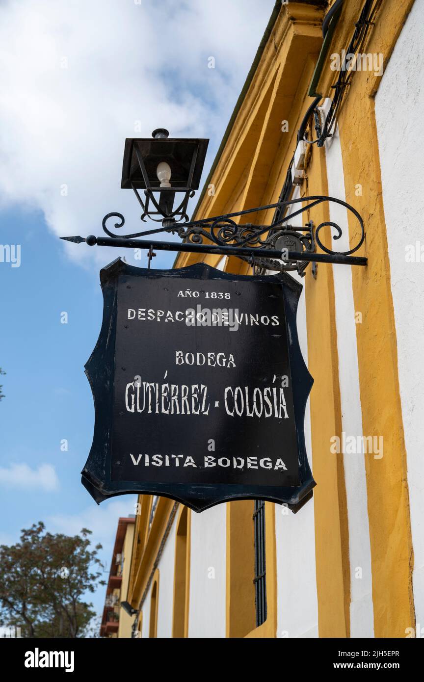 A sign on an old sherry warehouse and bodega painted in white with yellow skirting, by Gutierrrez Colosia in Puerto de Santa Maria Spain Stock Photo