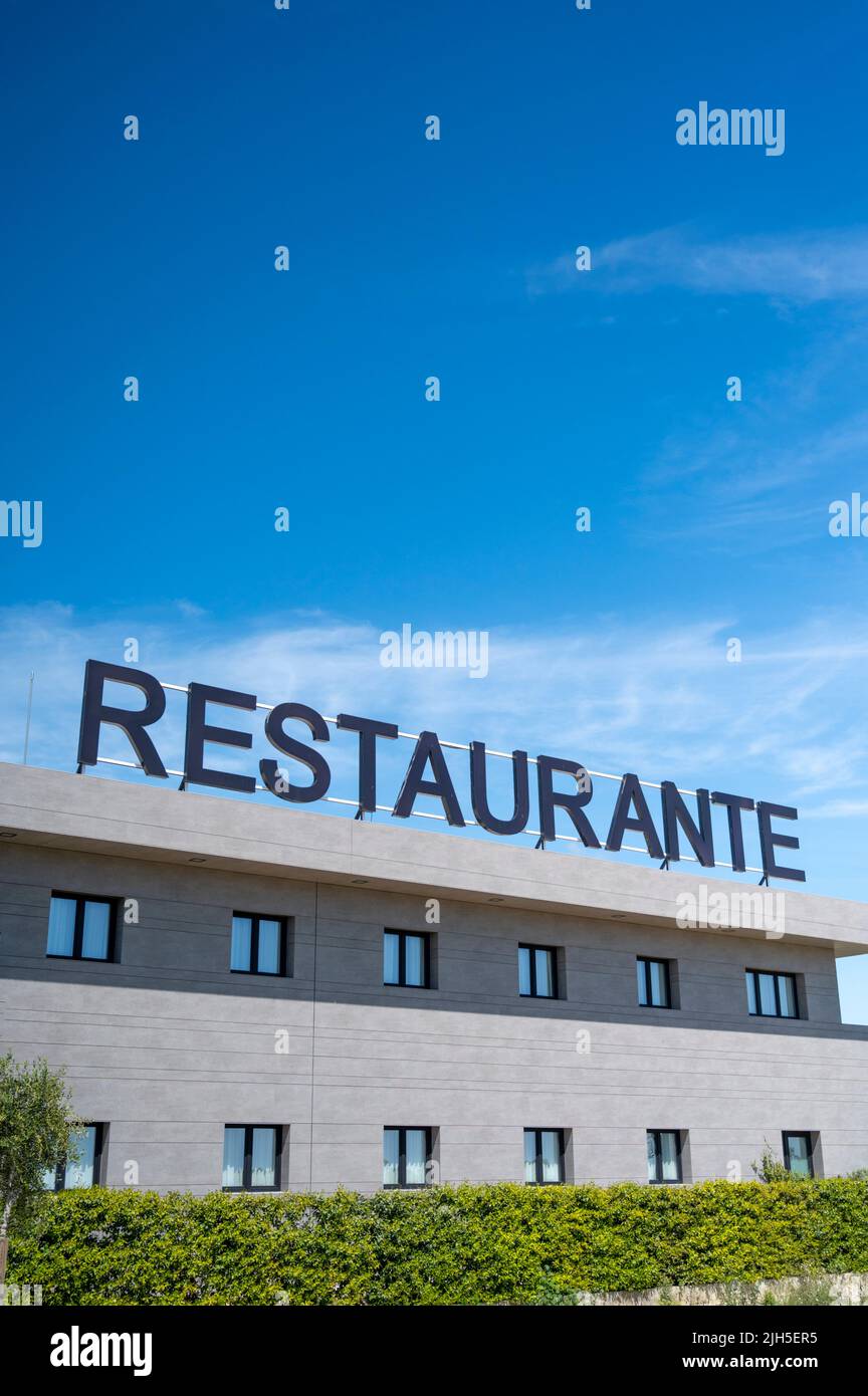 A Repsol restaurant and hotel advertising sign at a service area in Spain against a colourful blue sky Stock Photo