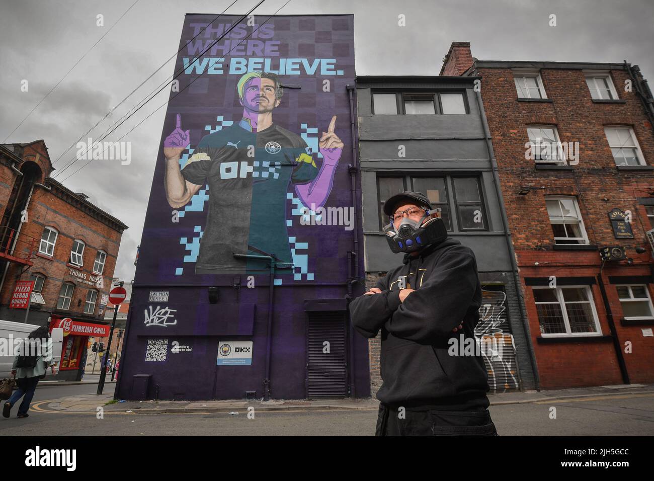 EDITORIAL USE ONLY Graffiti artist AKSE P19 unveils his Cyber-Punk mural of Manchester City FC star Jack Grealish in Manchester, created with Global Street Art Agency, as crypto trading platform OKX celebrates becoming the Official Training Kit Partner of MCFC for the 2022/2023 season. Picture date: Friday July 15, 2022. Stock Photo