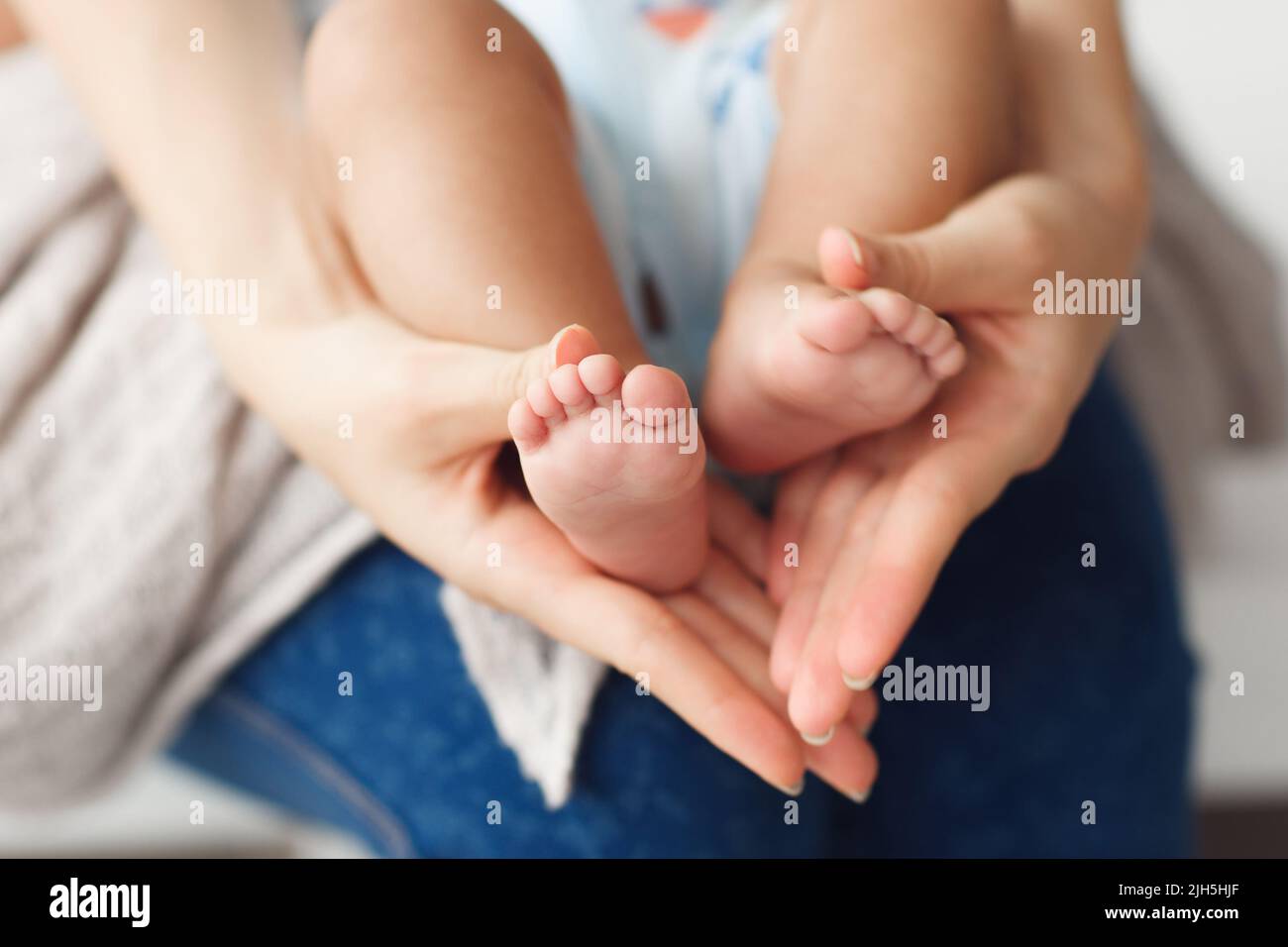 Newborn baby legs in mother hands, closeup Stock Photo Alamy