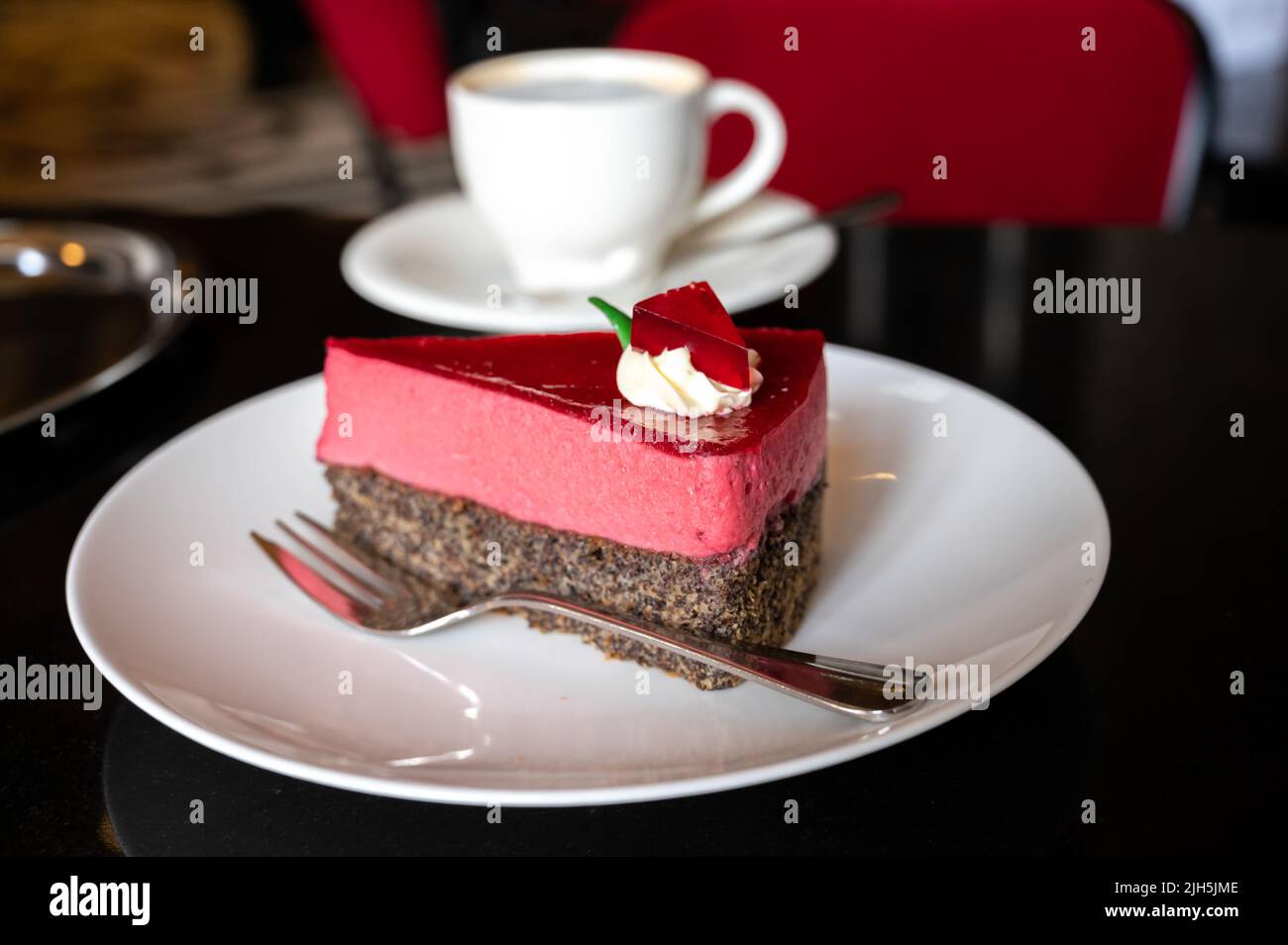 Piece of famous Poppy seed cake with raspberry mousse of Austrian origin served with whipped
