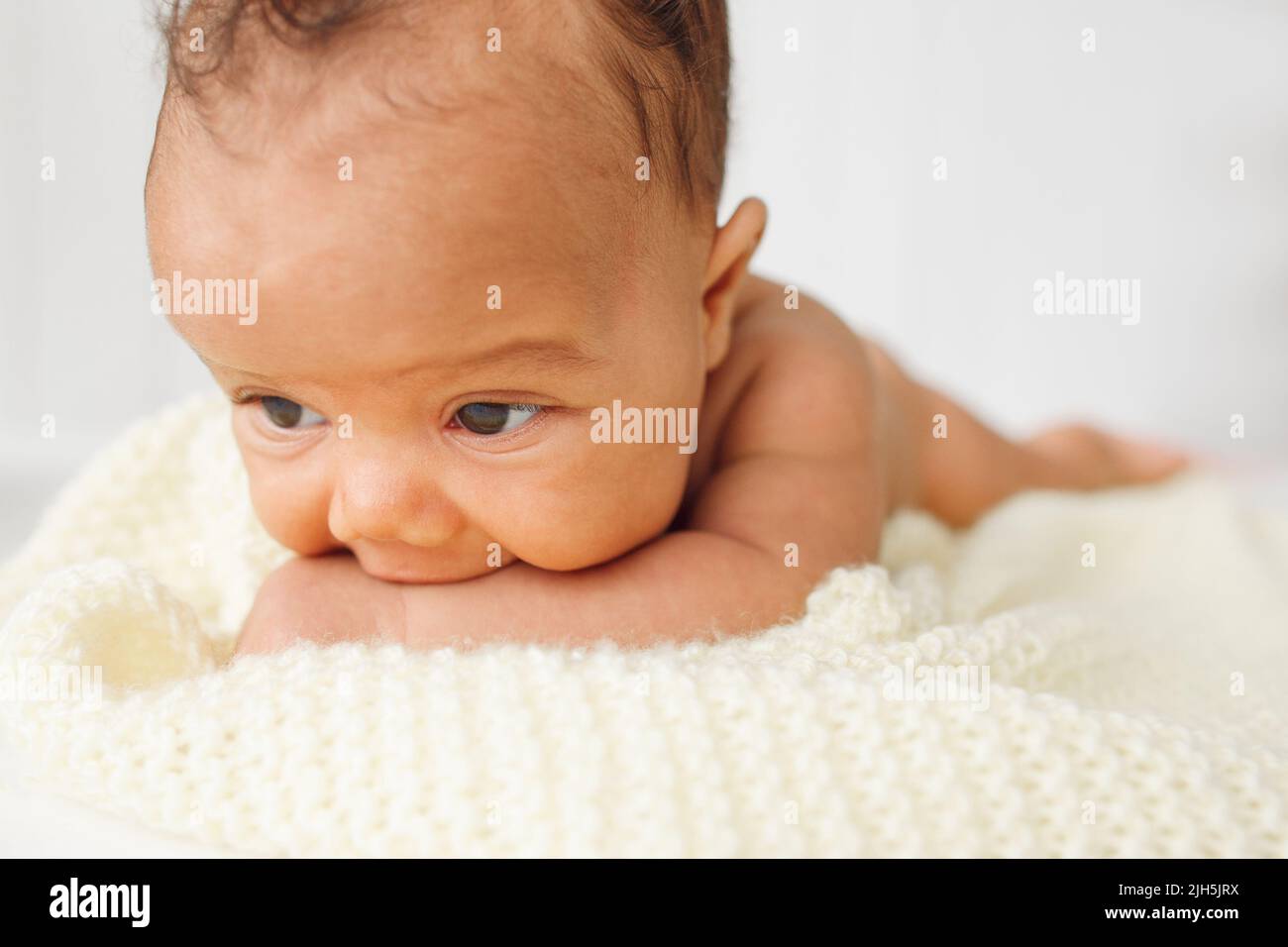 Newborn baby laying stomach down on bed Stock Photo Alamy
