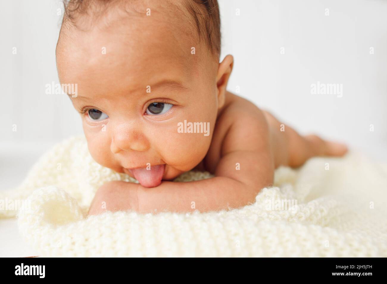 Newborn baby laying stomach down on bed Stock Photo Alamy
