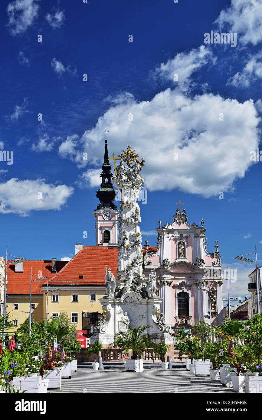 Franciscan church and Holy Trinity statue in St Polten, Austria, vertical Stock Photo