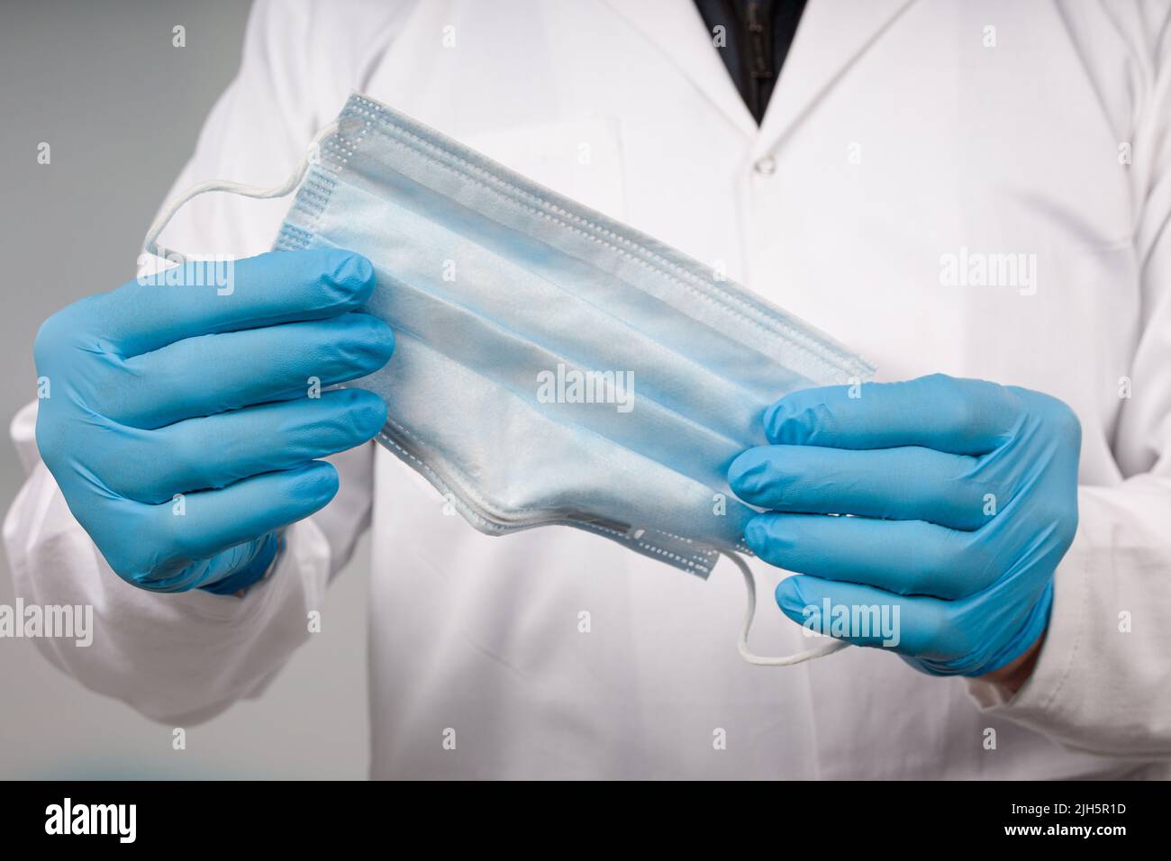 close up of doctor's hand with a medical face mask for protection against infection Stock Photo