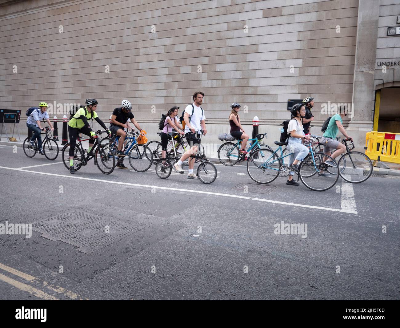 Queue of cyclists outside the walled perimeter of  The Bank of England, Lothbury, London Stock Photo