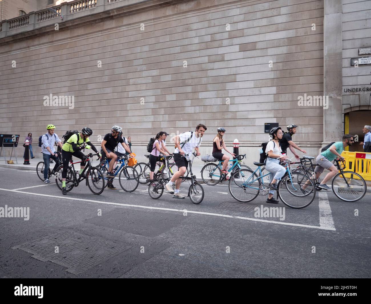 Queue of cyclists outside the walled perimeter of  The Bank of England, Lothbury, London Stock Photo