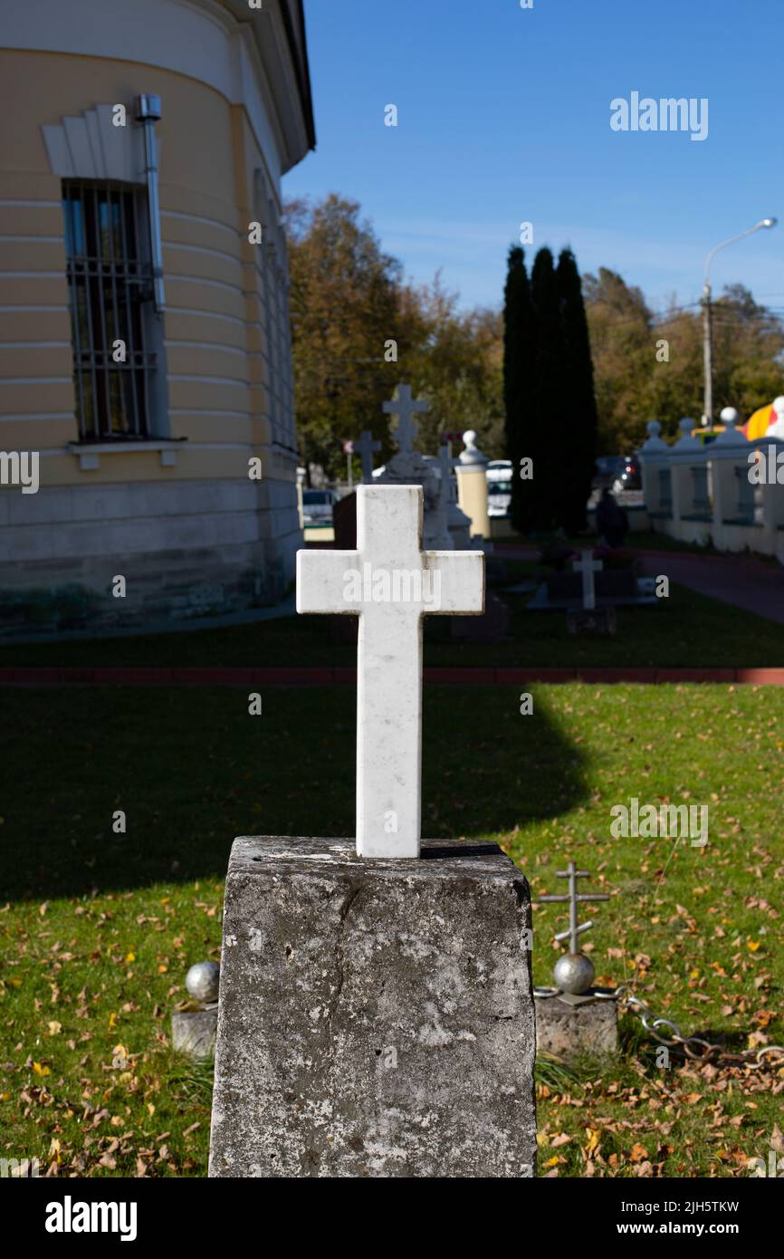 Marble white cross in the ancient church cemetery vertical photography