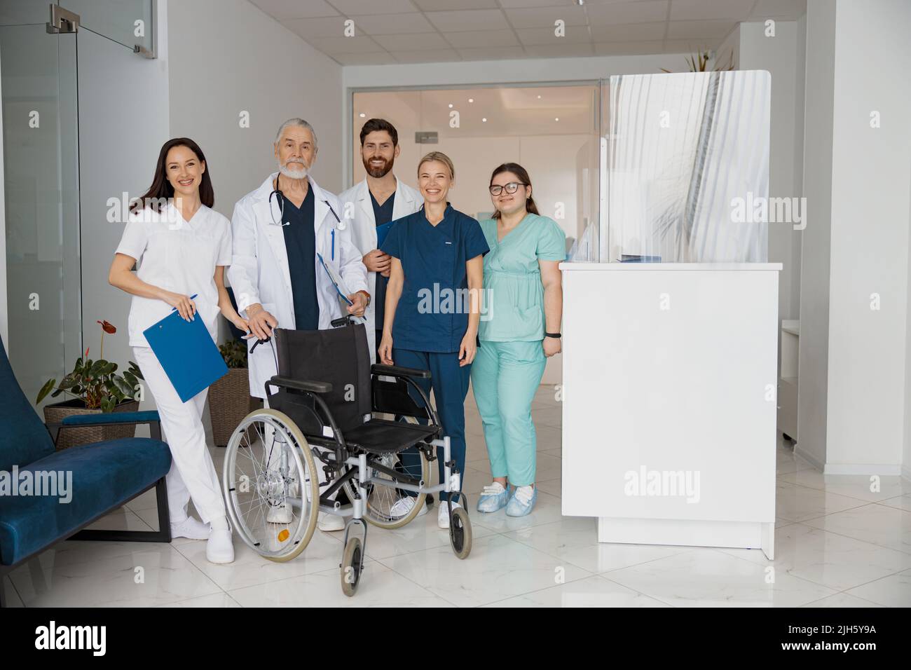 Doctors In Uniform Group of professional doctors in uniform standing in clinic hall with ...