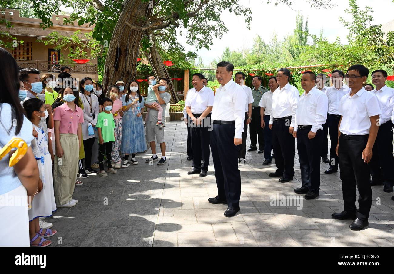 Urumqi, China's Xinjiang Uygur Autonomous Region. 14th July, 2022. Chinese President Xi Jinping, also general secretary of the Communist Party of China Central Committee and chairman of the Central Military Commission, talks with tourists while visiting Grape Valley in Turpan, northwest China's Xinjiang Uygur Autonomous Region, July 14, 2022. Xi made an inspection tour in Xinjiang from Tuesday to Friday. Credit: Li Xueren/Xinhua/Alamy Live News Stock Photo