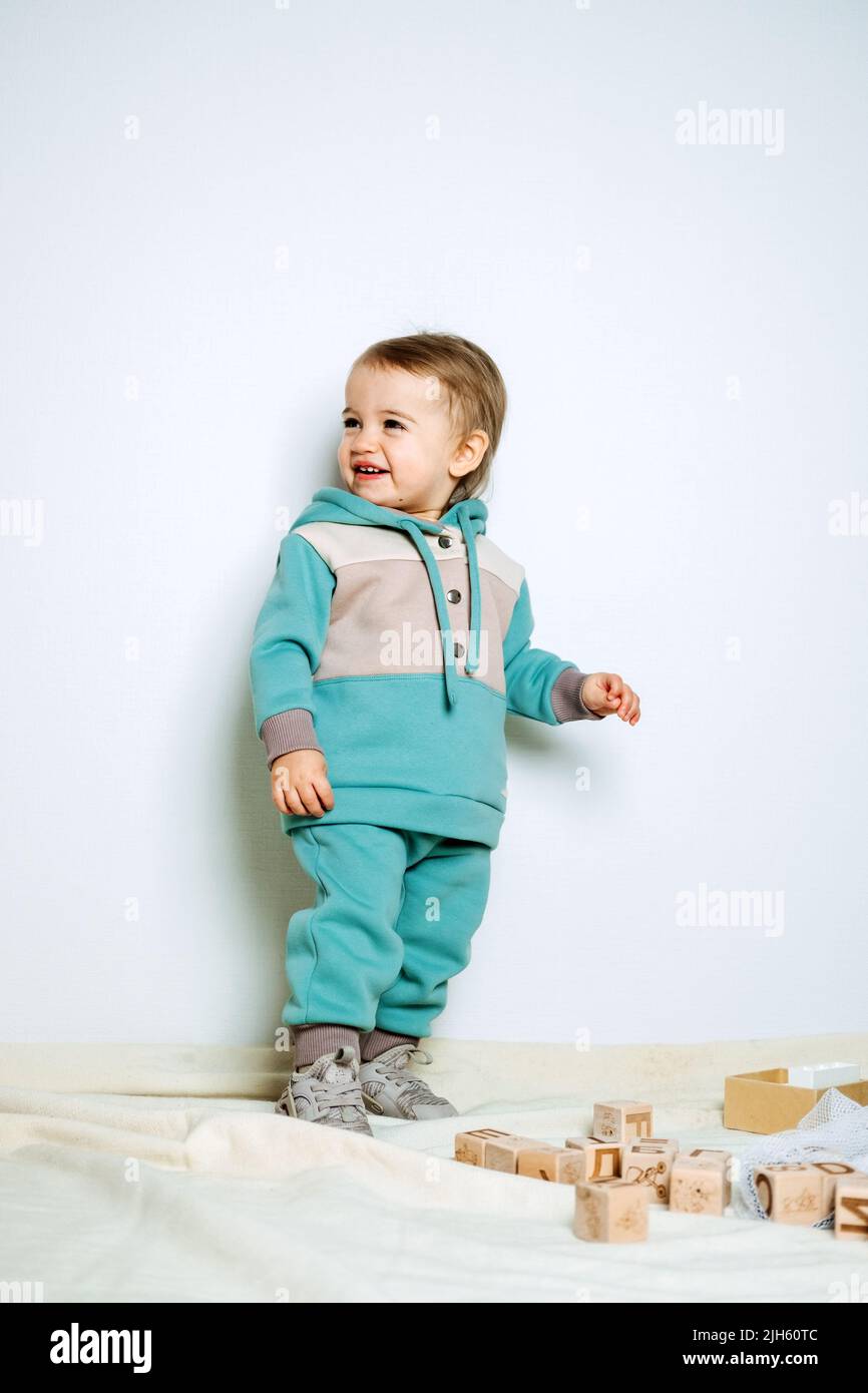 Baby fashion. Unisex clothes for babies. Cute baby in cotton set suit on light background. Stock Photo