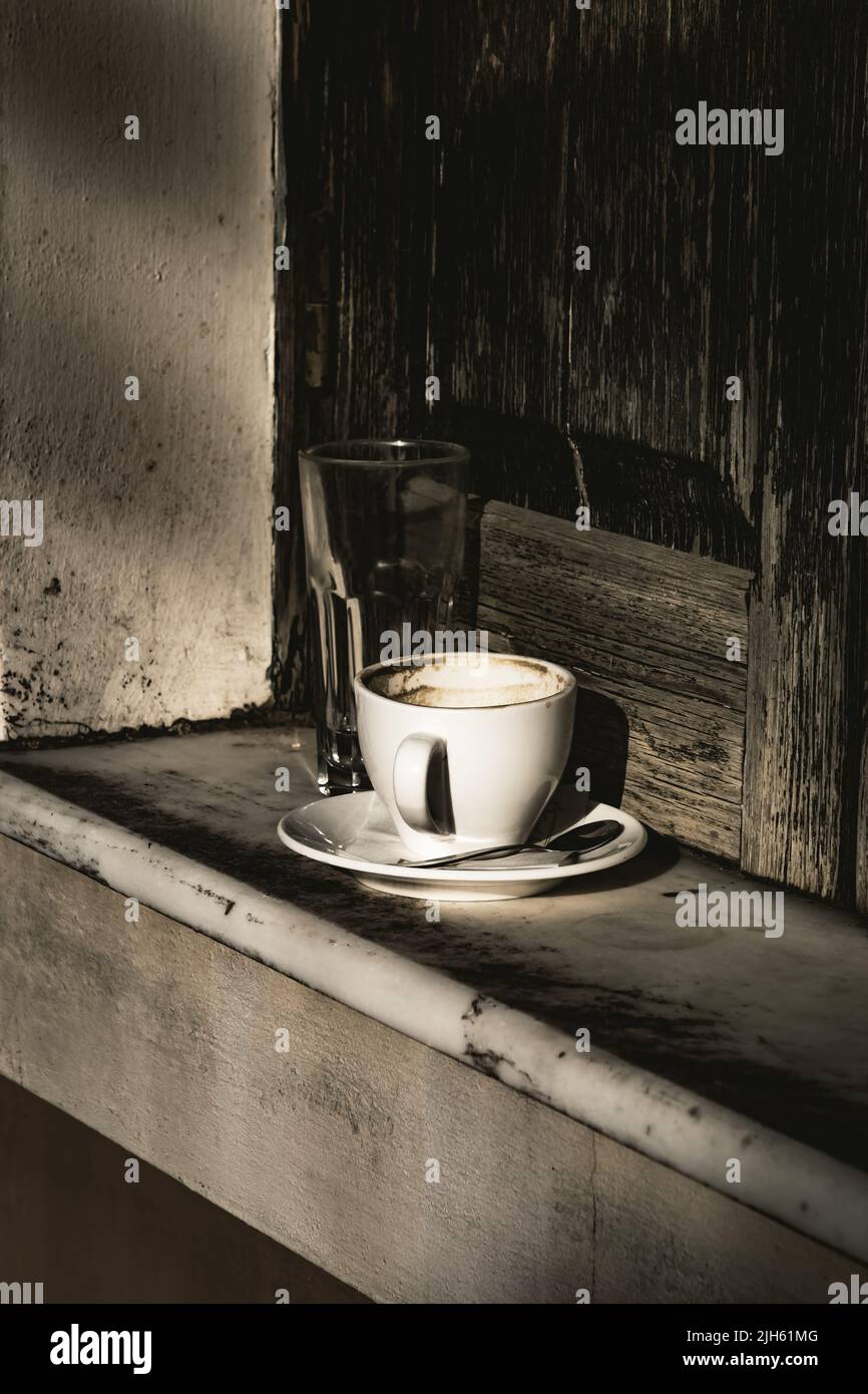 Coffee mug and water glass on window sill Stock Photo - Alamy