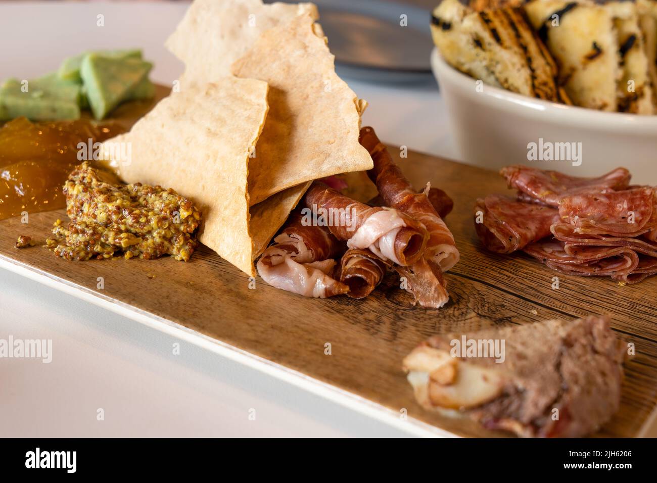 Charcuterie Board with selective focus contains meats, cheese, chutney, and mustard Stock Photo
