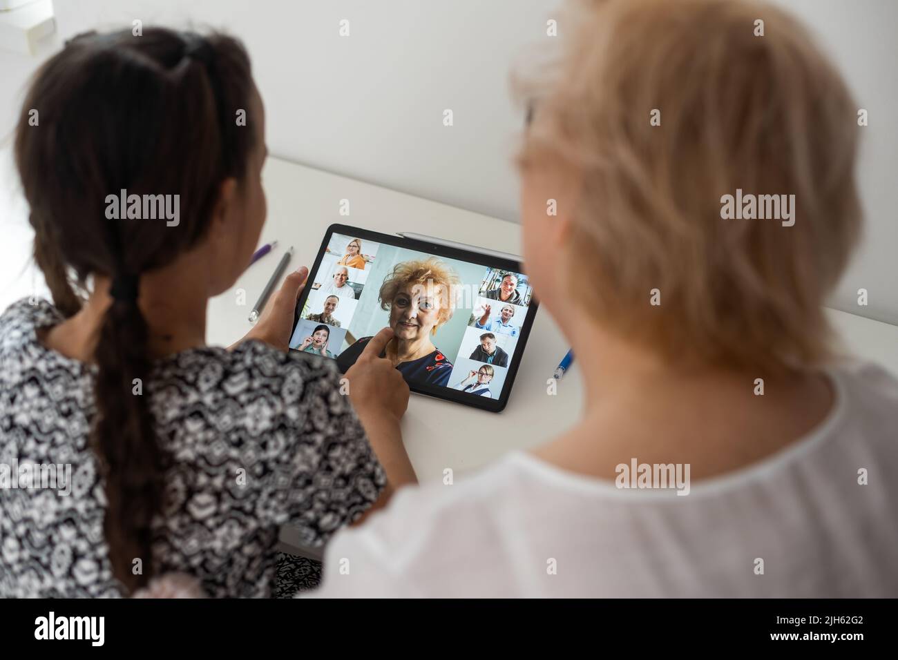 Cute little girl with her grandmother looking at tablet at home Stock ...