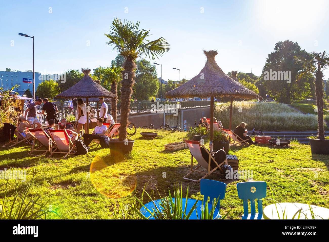 People relaxing on deck chairs on a sunny day at Miami Wars food market and bar along the Vistula Riverside, Solec, Warsaw, Poland Stock Photo