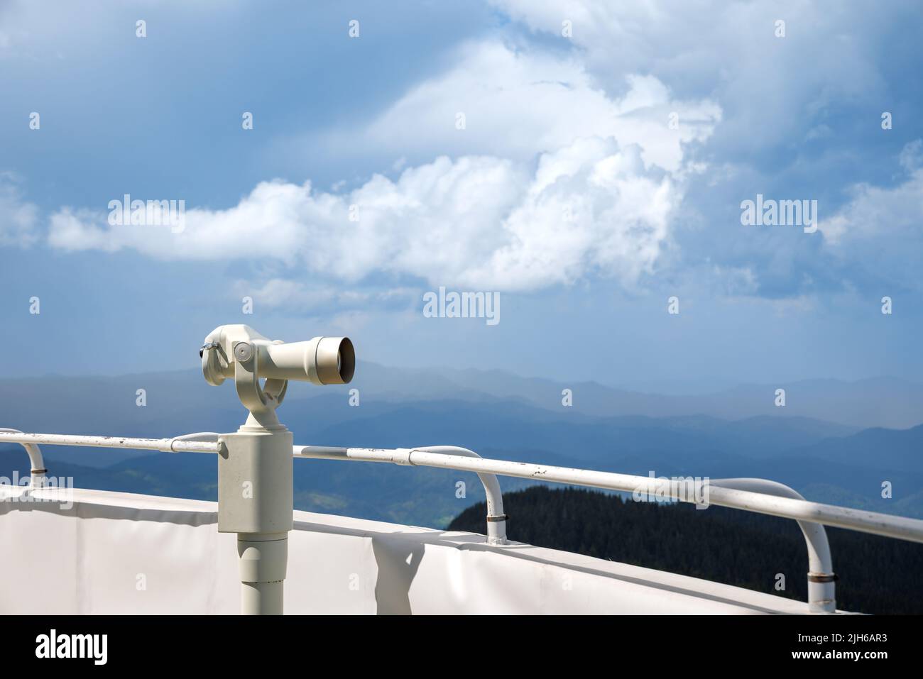 A modern metal orbital telescope of white color on a high observation
