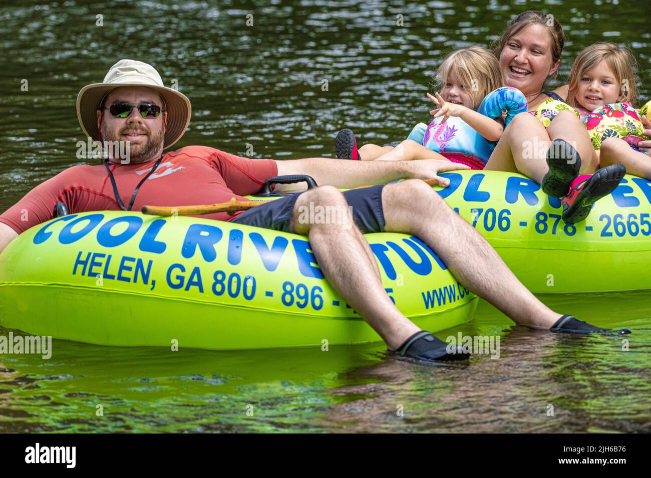 Family enjoying a tubing trip together on the Chattahoochee River through Helen, Georgia, in the Northeast Georgia Mountains. (USA) Stock Photo